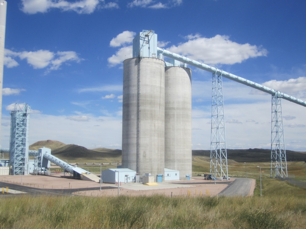 10 story tall Concrete Silo situated in a field with rolling hills and blue sky